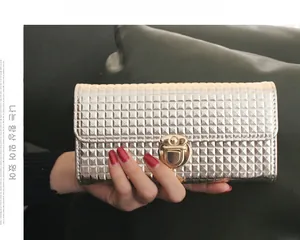Détail de pochette dorée avec texture pyramidale et fermoir rotatif doré élégant
