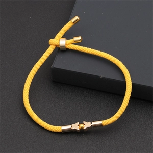 Detail of yellow braided rope bracelet with golden butterfly charms and adjustable slider