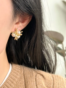 Detailed view of pearl cluster earrings on model with 18k gold plating and vintage style