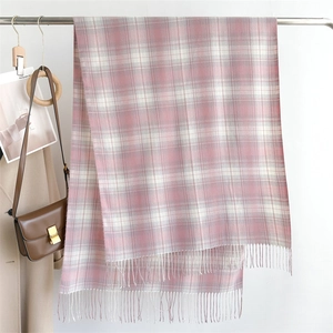 Close-up of pink and white plaid scarf with soft fringe details and wool texture