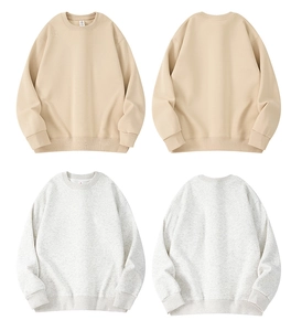 Detail view of crew neck sweatshirts in apricot and gray colors with ribbed cuffs