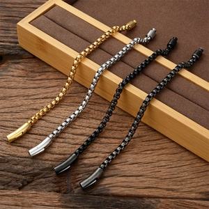 Herren-Edelstahlarmbänder in Gold, Silber, Schwarz und Gunmetal auf einem Holzständer