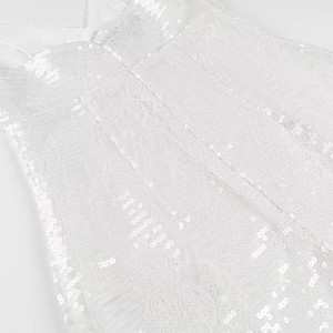 Detailansicht von weißem Pailletten-Spitzenstoff und Trägern an einem Partykleid