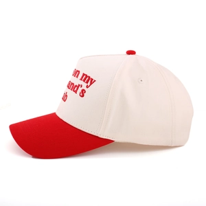 Close-up of red embroidery on side of white and red cotton baseball trucker hat
