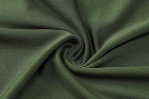 Détail du tissu tricoté vert armée avec plis radiaux élégants et texture fine