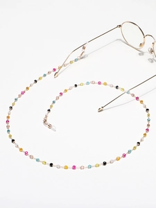 Détail du cordon à lunettes en perles de cristal colorées et chaîne en métal doré avec boucles