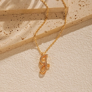 Detail of 18K gold plated letter f pendant with shimmering cubic zirconia inlay