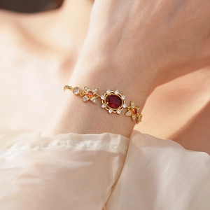 Detail eines Vintage-Goldarmbands mit rotem Edelstein und floralen Zirkonia-Akzenten