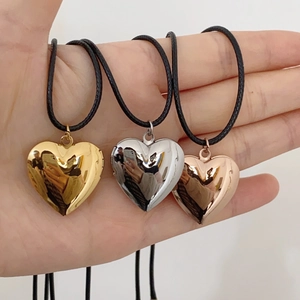 Close-up of heart-shaped floating locket pendants in gold, silver, and rose gold finishes
