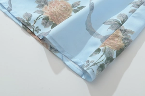 Dettaglio ravvicinato del tessuto blu con stampa floreale rosa e cuciture dell'orlo