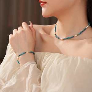 Detail of titanium steel necklace and bracelet set with natural blue stones and pearls