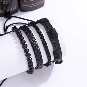 Détail d'un lot de 4 bracelets en cuir noir avec perles en bois et textures tressées