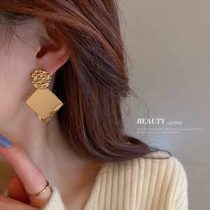 Geometric gold square sequin drop earrings on model for a minimalist style