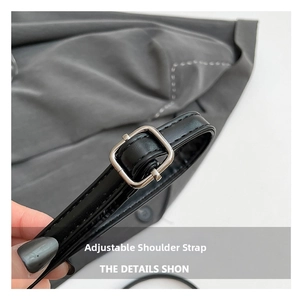 Detail of black leather adjustable shoulder strap with silver metal buckle and fine stitching