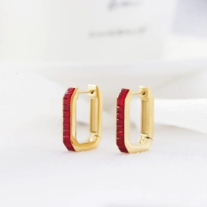 Macro shot of gold rectangle hoop earrings with inlaid red square cut gemstones