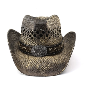 Detail of vintage straw cowboy hat with embroidered band and metallic buckle relief