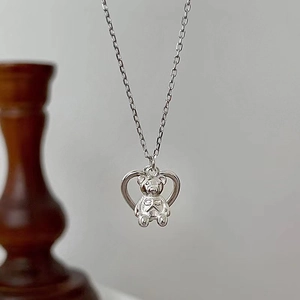 Macro close-up of a S925 sterling silver heart-shaped pendant with a cute bear insert