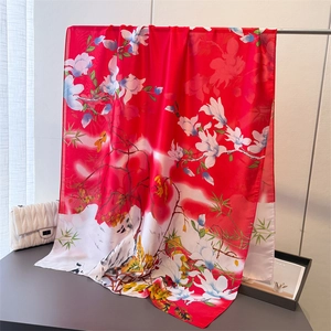 Detailed view of red silk scarf with magnolia and bird patterns in Chinese style