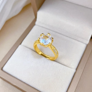 Gold plated open ring featuring a clear zircon centerpiece on a luxury jewelry box display