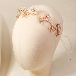 Rose gold flower bridal hair vine with crystals, pearls and ribbon on a mannequin head