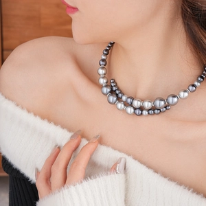 Détail d'un collier de perles double épaisseur gris et argent avec des intercalaires strass