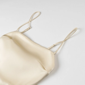 Champagne silk satin dress featuring adjustable spaghetti straps and smooth fabric texture