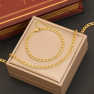 Golden Figaro chain heart necklace and bracelet jewelry set on beige storage box