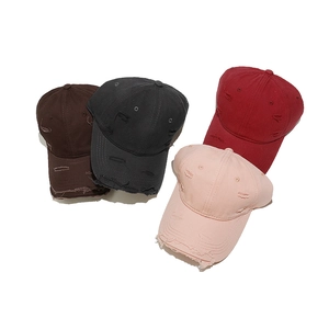 Vintage distressed baseball caps for women with frayed holes and worn-out brim design