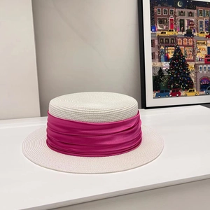 Close-up of fine woven straw hat texture with pleated magenta satin ribbon detail