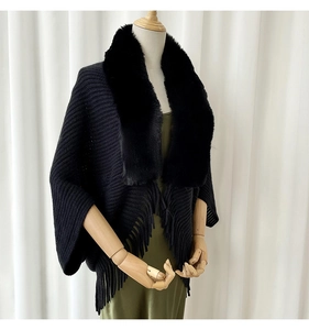 Detailed view of luxury black knit shawl featuring premium faux fur collar and fringe hem