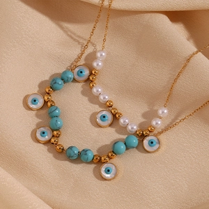 Detail of 18K gold plated necklace with blue turquoise beads and evil eye charms