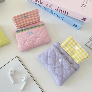 Close-up of quilted fabric card holder with snap closure in pastel pink and purple colors