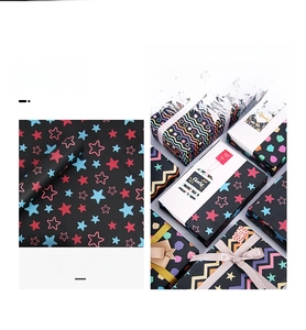 Detail of black wrapping paper with colorful stars and patterns on festive gift boxes