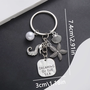Detail of silver ocean keychain with seahorse, shell charms and Dreaming of the Sea tag