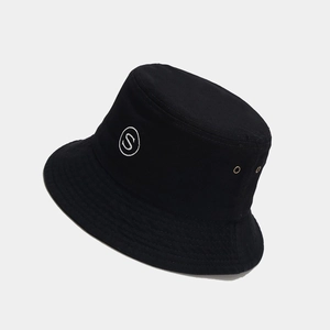 Close-up of black bucket hat with white S letter embroidery and metal eyelet detail