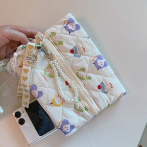 Detail of quilted cotton pouch with cartoon print and elegant pearl strap