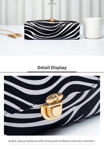 Detail display of zebra print crossbody bag showing gold buckle and textured base