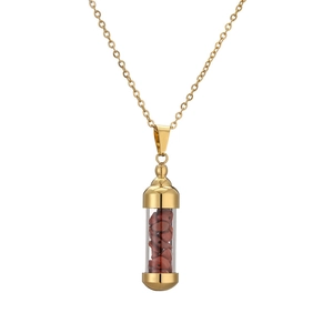Detail of gold capsule pendant necklace with red crushed stones and polished finish
