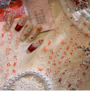 Macro detail of Chinese style nail art stickers with red butterflies and bamboo designs