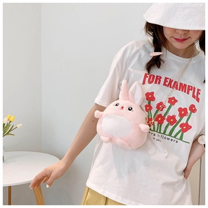 Detail view of a pink plush bunny crossbody bag with golden chain strap on a model