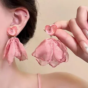 Detail of pink heart-shaped earrings with chiffon flower petals and opal-like luster