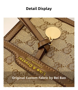 Detail of bear jacquard canvas bag with premium leather trim and gold charm