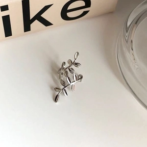 Detailed close-up of a silver-finish leaf shaped ear cuff with a polished metallic shine