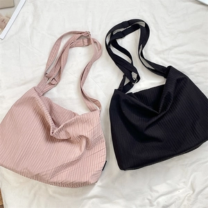 Detail of adjustable metal buckle and ribbed texture on pink and black canvas bags