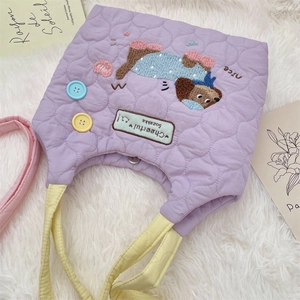 Close-up of purple quilted tote bag with cute dog embroidery and colorful buttons