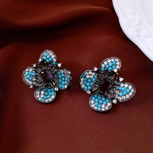 Gros plan détaillé de boucles d'oreilles papillon vintage avec perles bleues et zircone