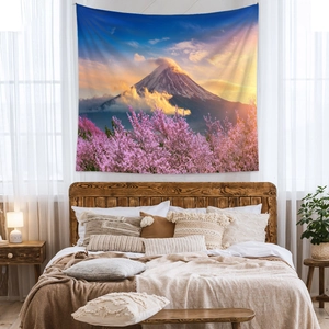 Mt Fuji tapestry with pink cherry blossoms hanging above a bed in a cozy bedroom