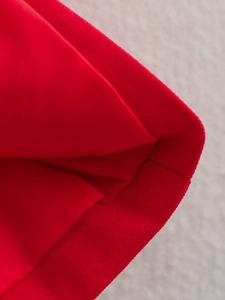 Gros plan de la texture du tissu rouge et des coutures sur l'ensemble gilet