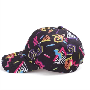 Detail view of cotton baseball cap with colorful Memphis style geometric print and curved brim