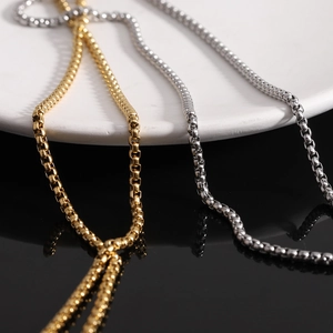 Detailed view of 26mm polished gold and silver stainless steel cross necklaces